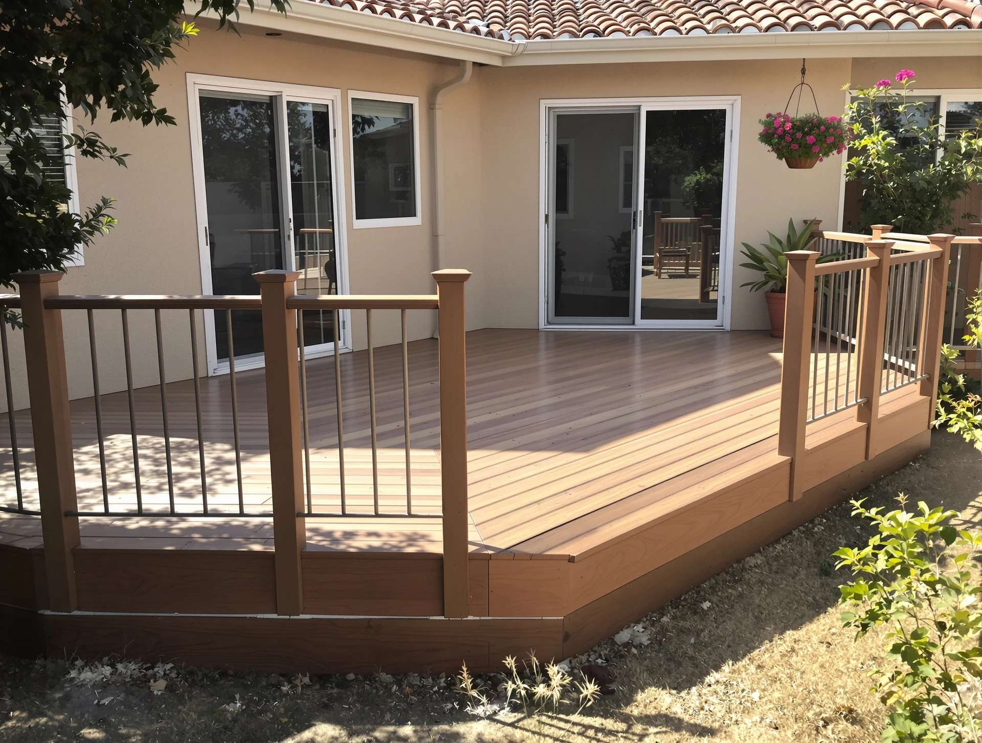 New patio deck with railing behind a stucco home